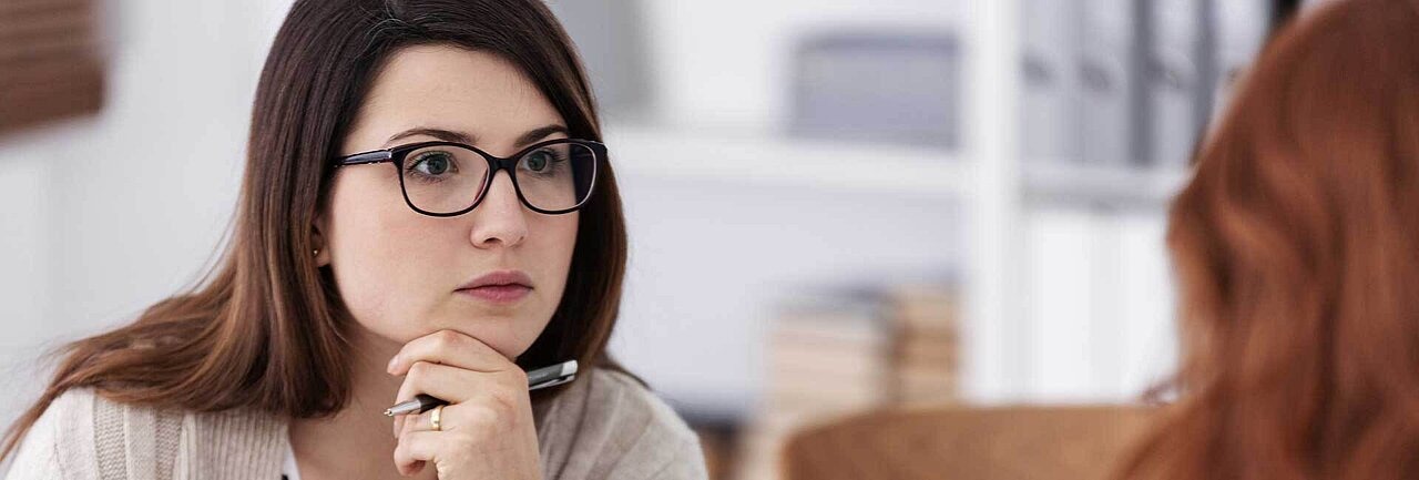 Lehrerin mit Brille unerthält sich mit einer Mutter