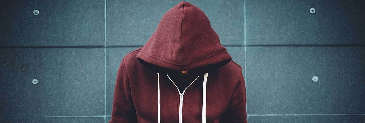 Teenager in rotem Hoddie mit gesenktem Kopf