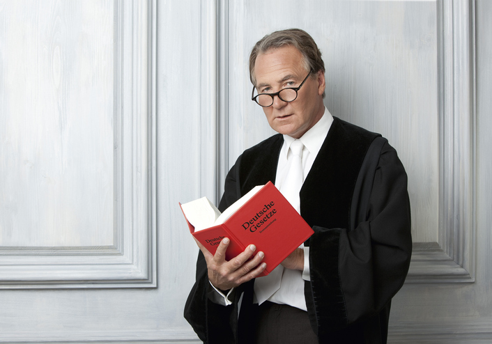 Moodbild "Warum für Jugendliche der Cannabiskonsum verboten ..." Älterer Herr in Richterrobe mit rotem Gesetzbuch in der Hand