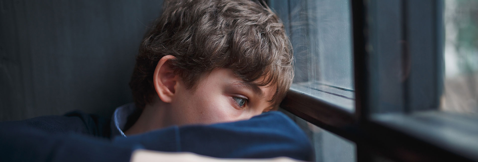 Moodbild "Wie wirkt Cannabis?" Depremierter Jugendlicher blickt aus dem Fenster