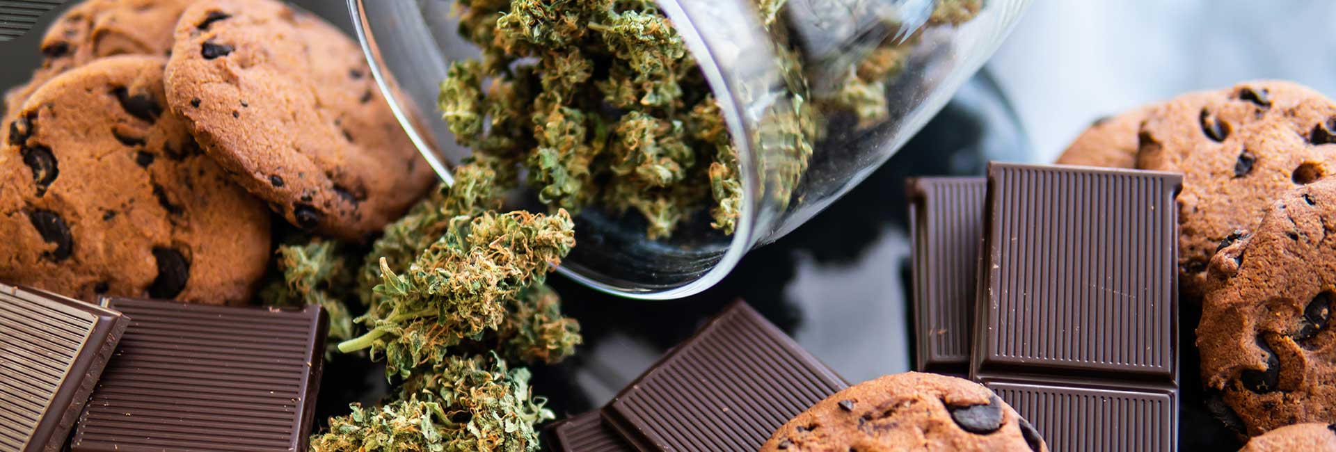 Ansammlung von Haschkeksen, Schokoladen und getrockneten Cannabisblüten