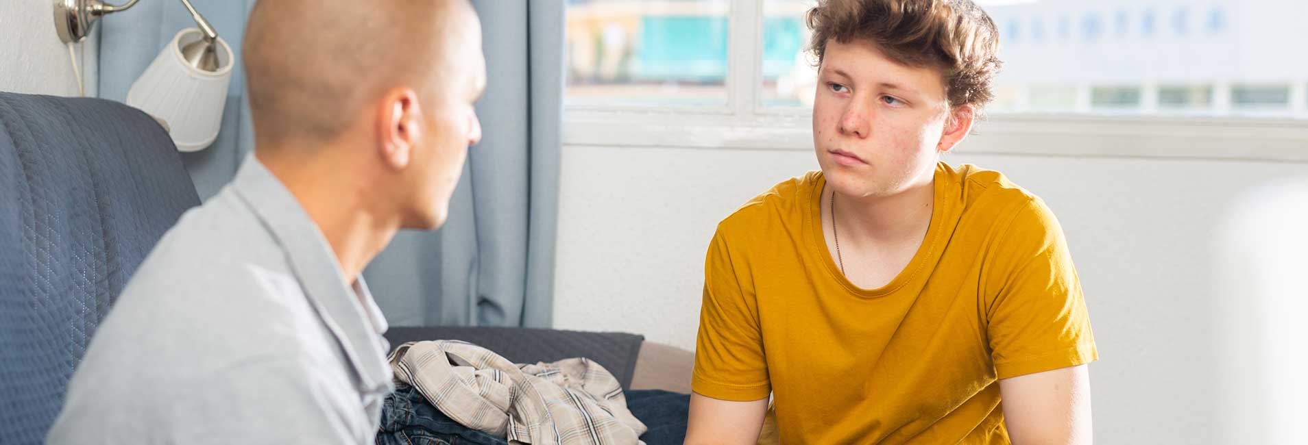Vater diskutiert mit seinem Sohn im Wohnzimmer