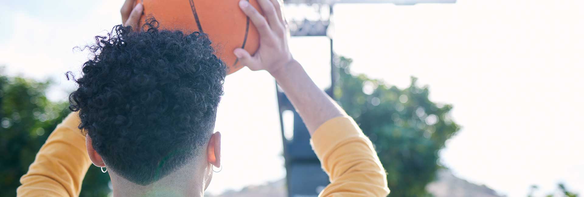 Moodbild "Cannabis? Es geht auch anders" Dunkelhäutiger Teenager zielt mit Basketball auf Korb