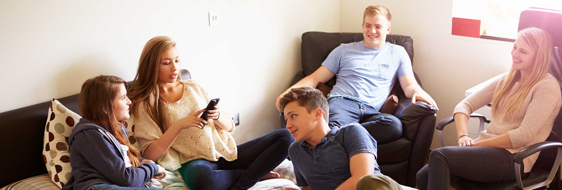 Moodbild "Umgang mit Cannabis" Fünf diverse Teenager entspannen auf Sofas im Raum