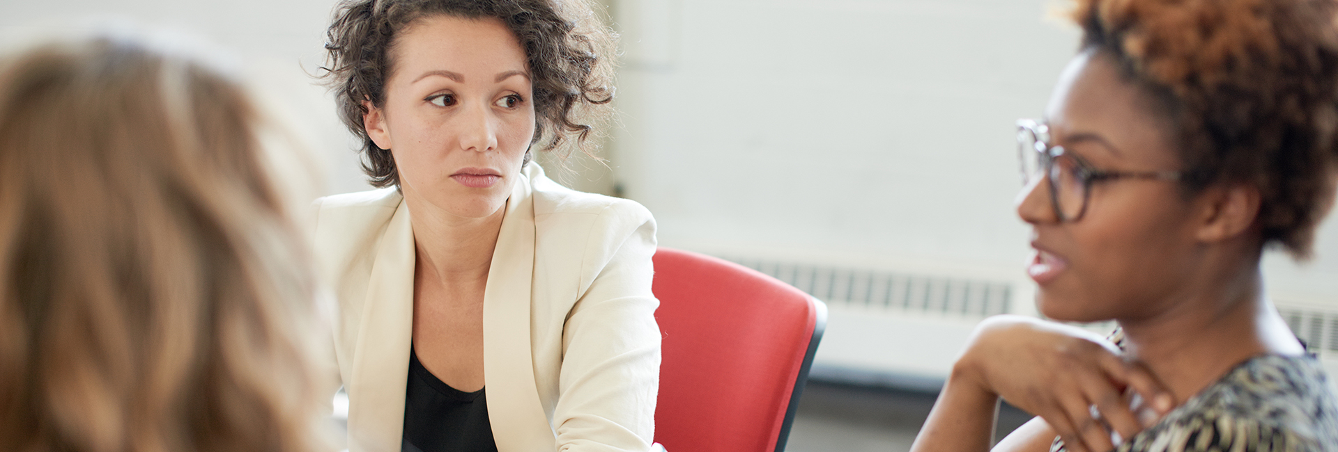 Eine Dreier-Gruppe diverser Frauen diskutiert