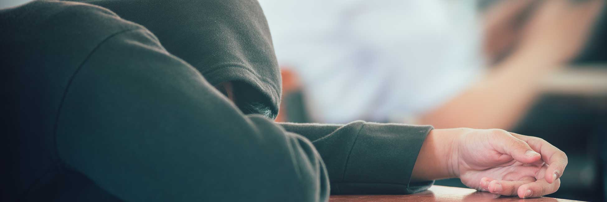 Cannabis: Langfristige Risiken und Sucht Teenager in grünem Hoodie ist im Schulunterricht eingeschlafen